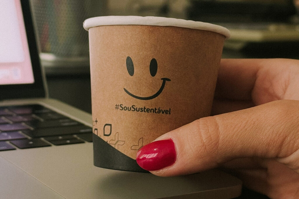 Mulher segurando copo de café de papel kraft pequeno para espresso e degustações em cafeterias e operações de food service