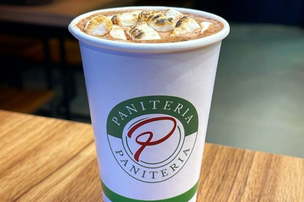 Copo de café de papel personalizado para bebidas quentes com chocolate em balcão de madeira