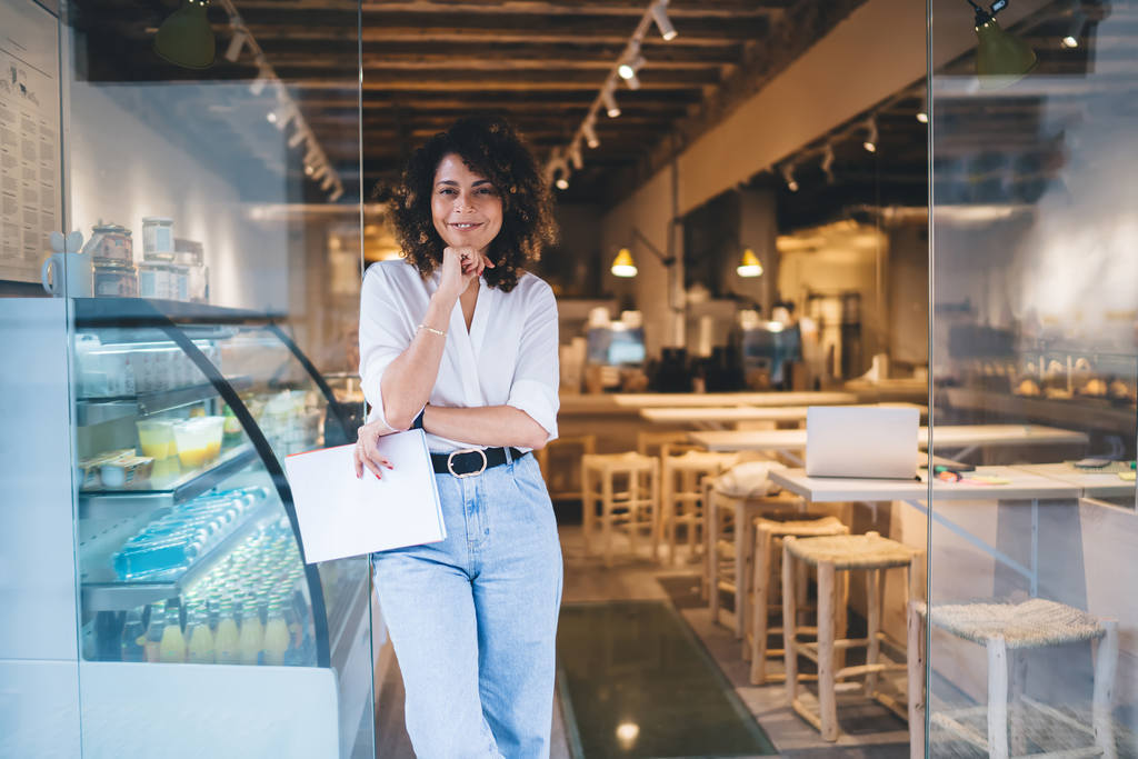 Empresária dentro de lanchonete planejando ideias de marketing digital para divulgação do negócio