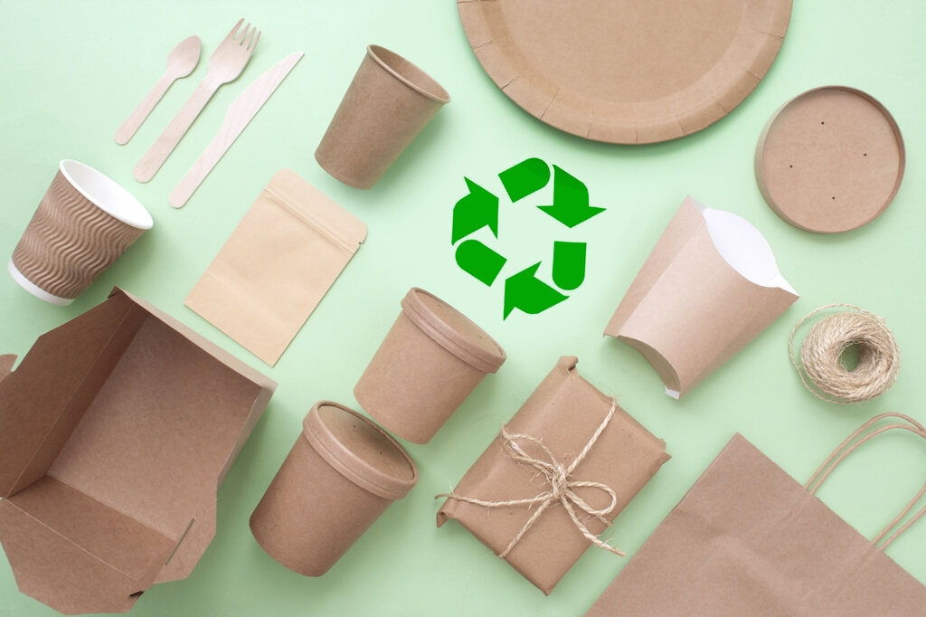 Embalagens, copos e potes de papel junto de pratos e talheres descartáveis, mateiriais recicláveis usados em negócios de alimentação