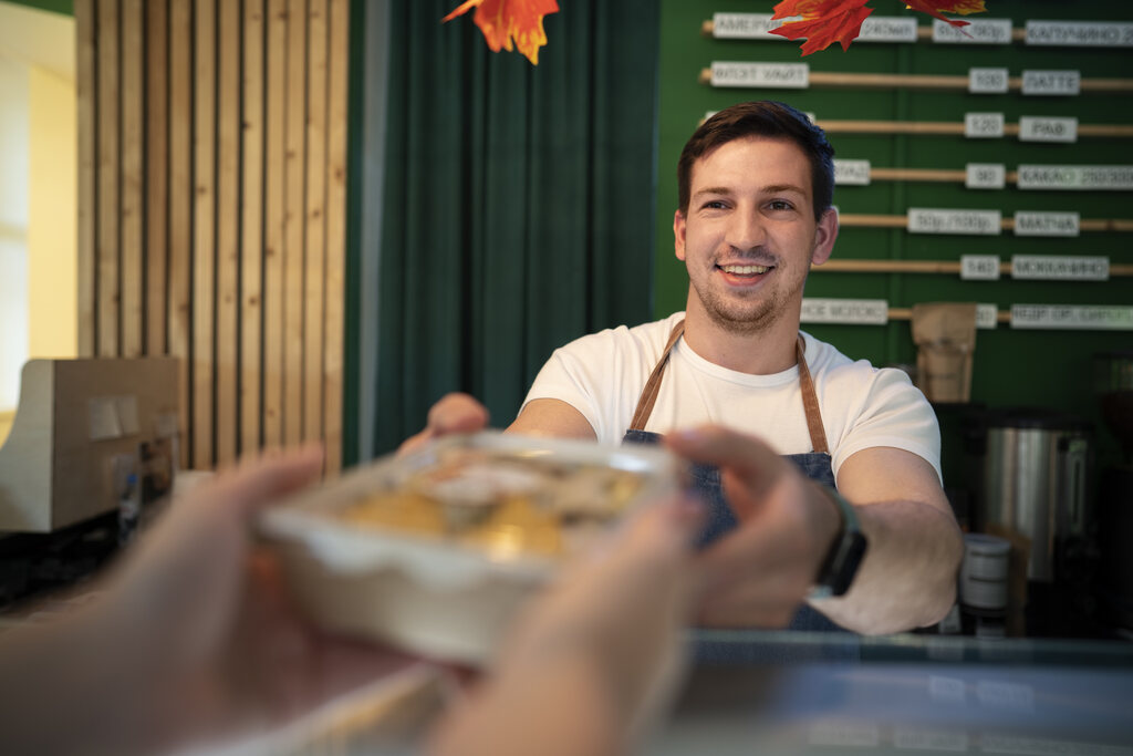 Homem vendendo comida para outro