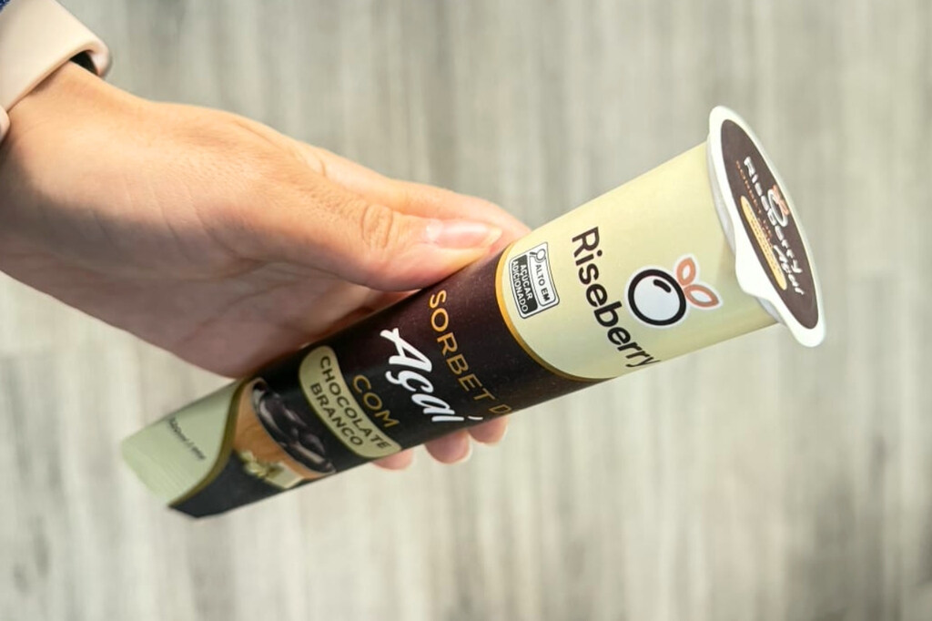 Pessoa segurando ice tube personalizado para açaí em embalagem de papel com tampa