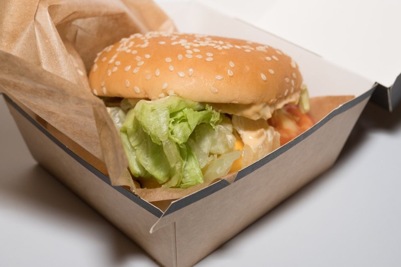 Hambúrguer dentro de uma caixa de papel, exemplo de embalagem para hamburgueria usada no delivery